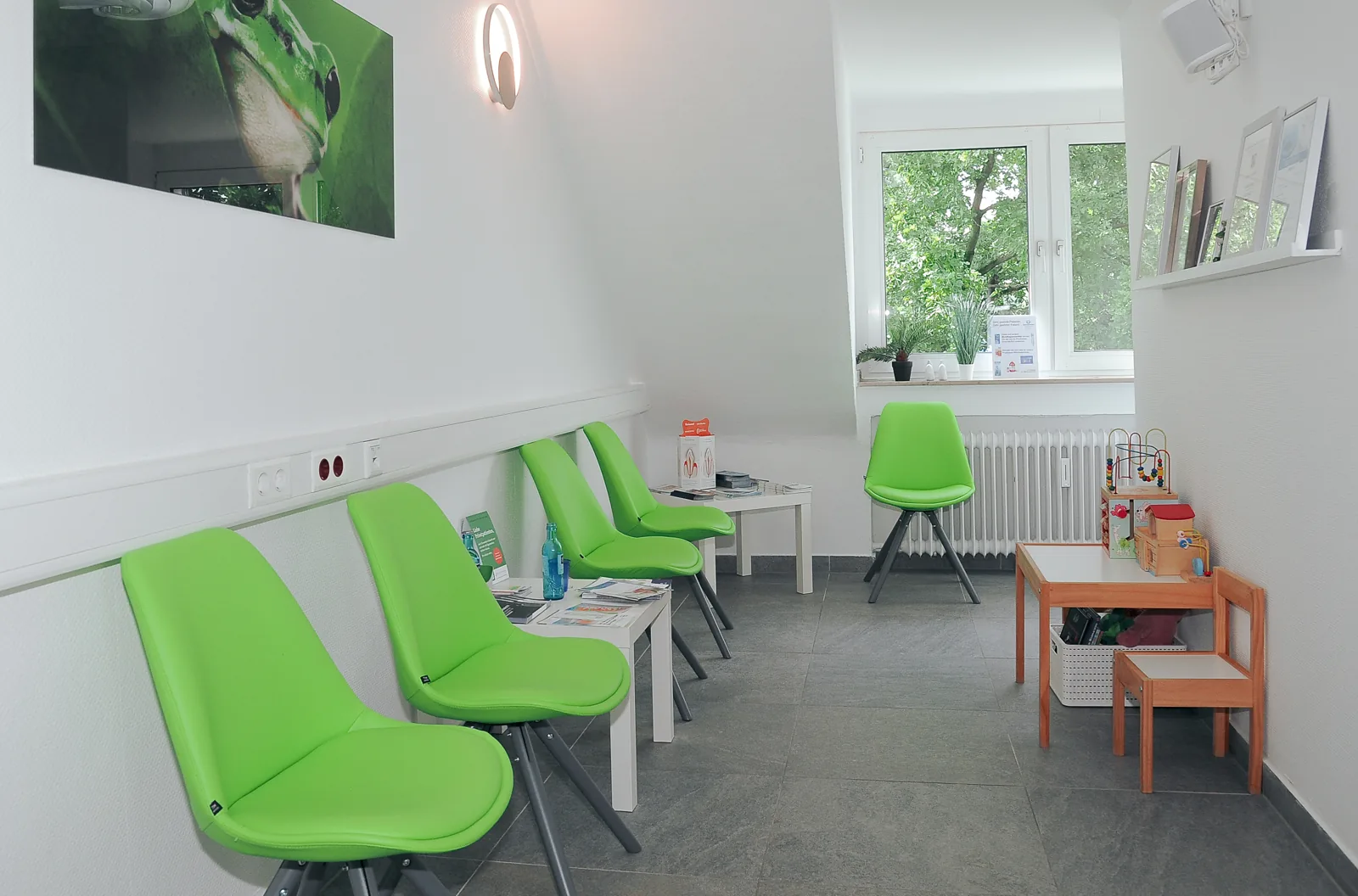 Wartezimmer der Zahnarztpraxis Dr. Dornbusch mit grünen Stühlen